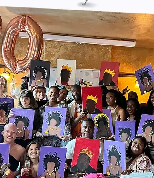 Large group toasting drinks around their paintings at a DWTN event